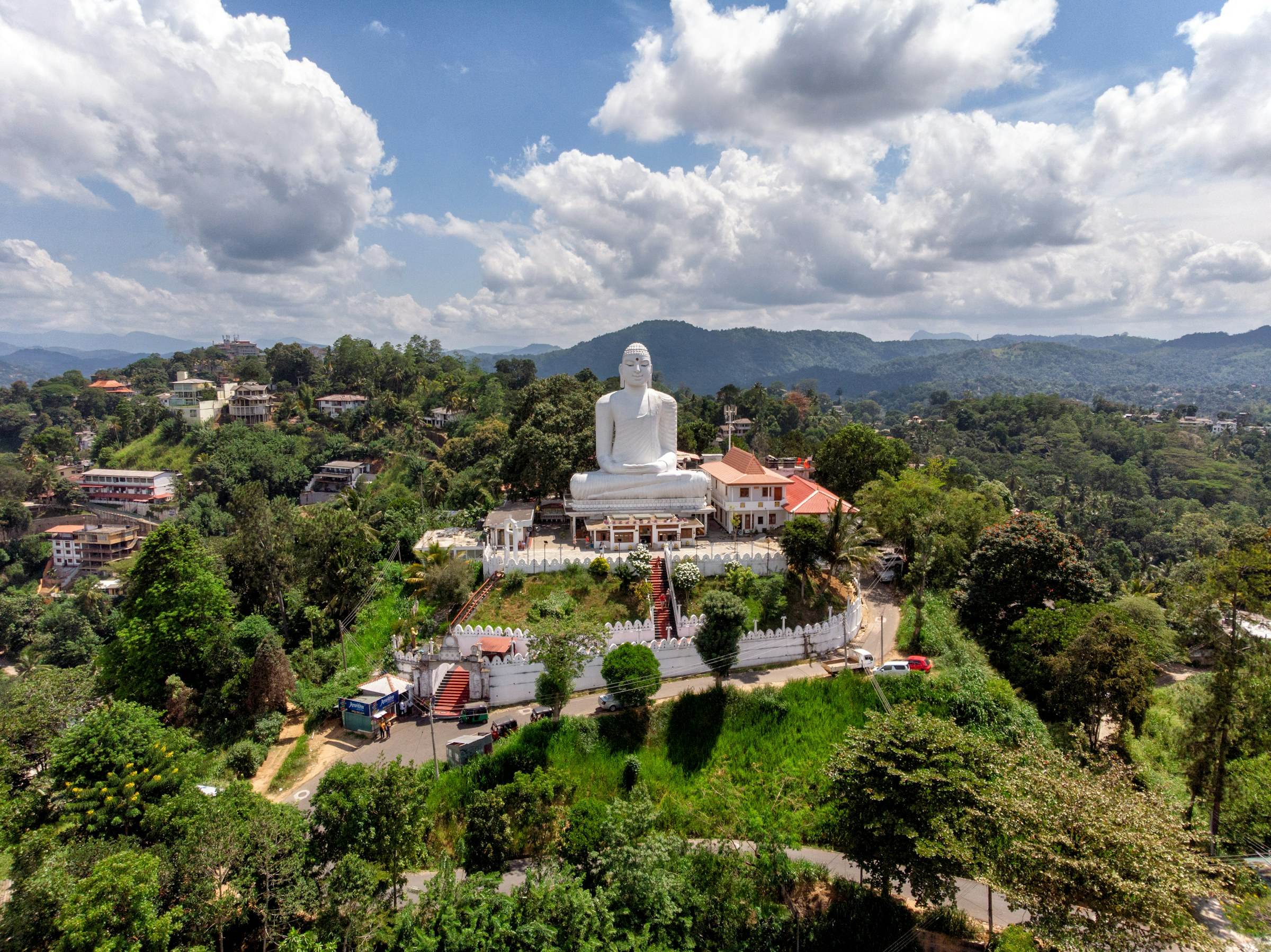 A large seated Buddha statue against an open sky