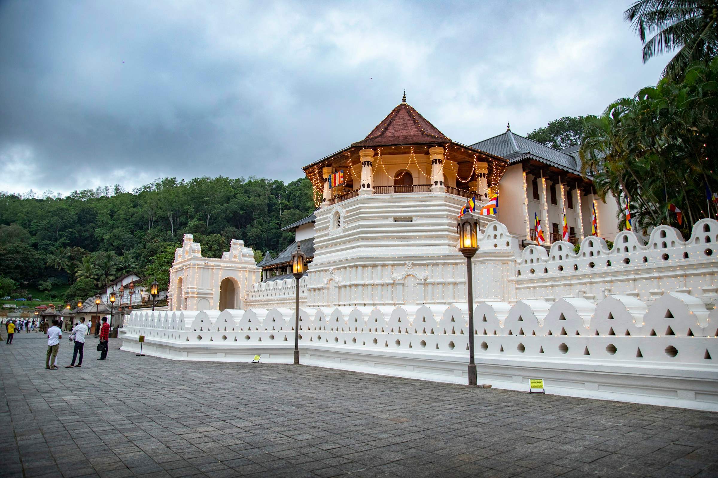 The white and gold Temple of the Tooth complex in Kandy seen across the water